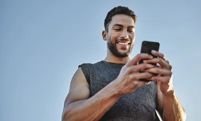 InsideTracker vs. Tally Health: a man smiles while looking at his cell phone.