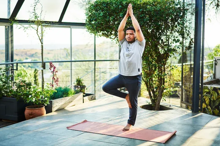 A man doing a yoga pose in a greenhouse - 6 Science-Backed Ways to Naturally Increase Testosterone