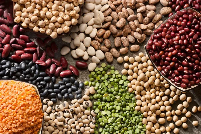 A variety of beans, peas, and lentils on a table.