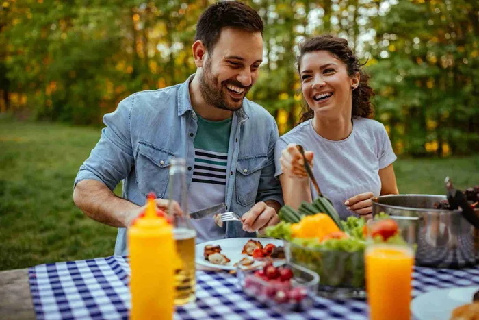 A man and woman sitting at a table with food - Are vegans healthier?